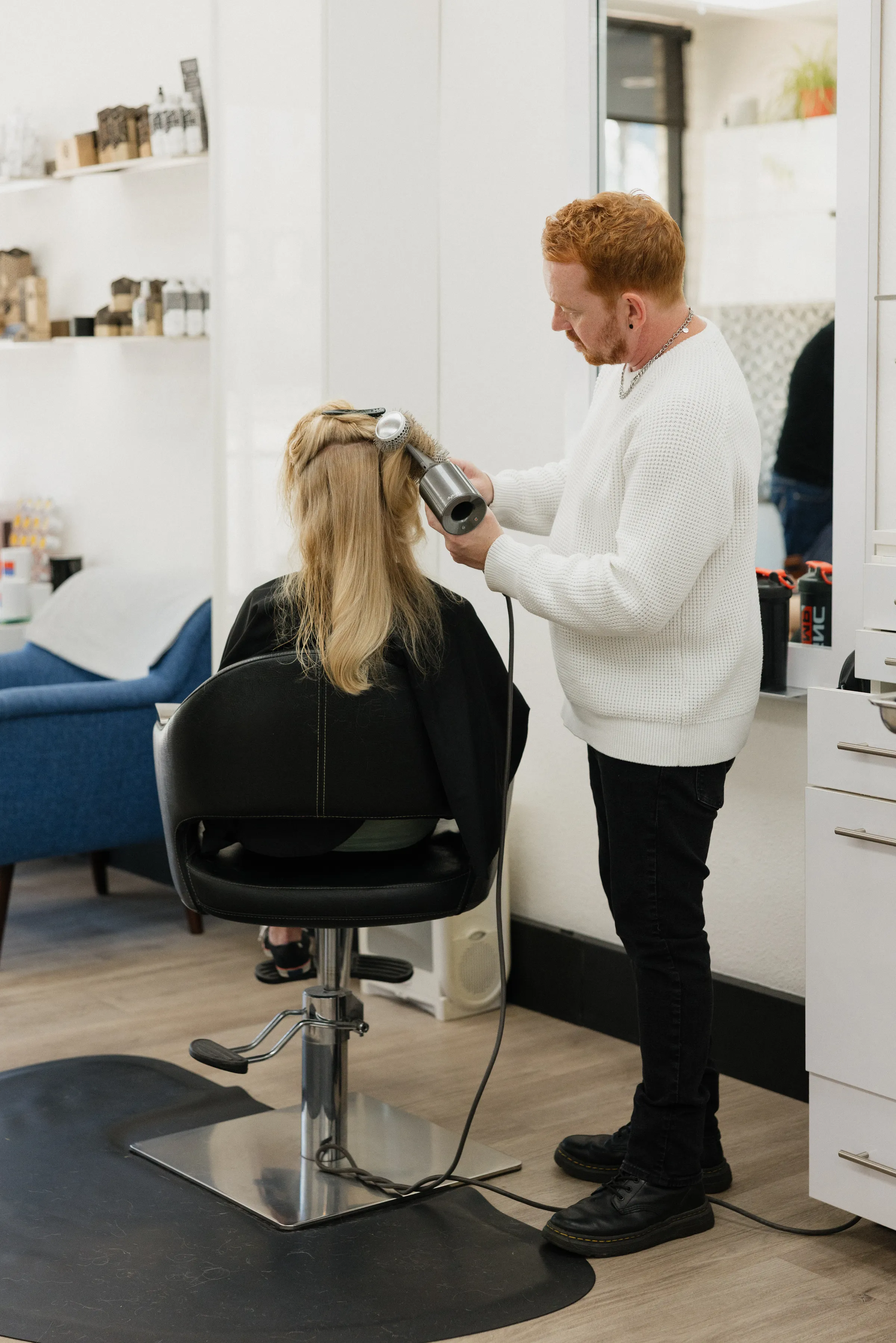 A stylist blow-drying a client at angelajoneshair, Palm Springs