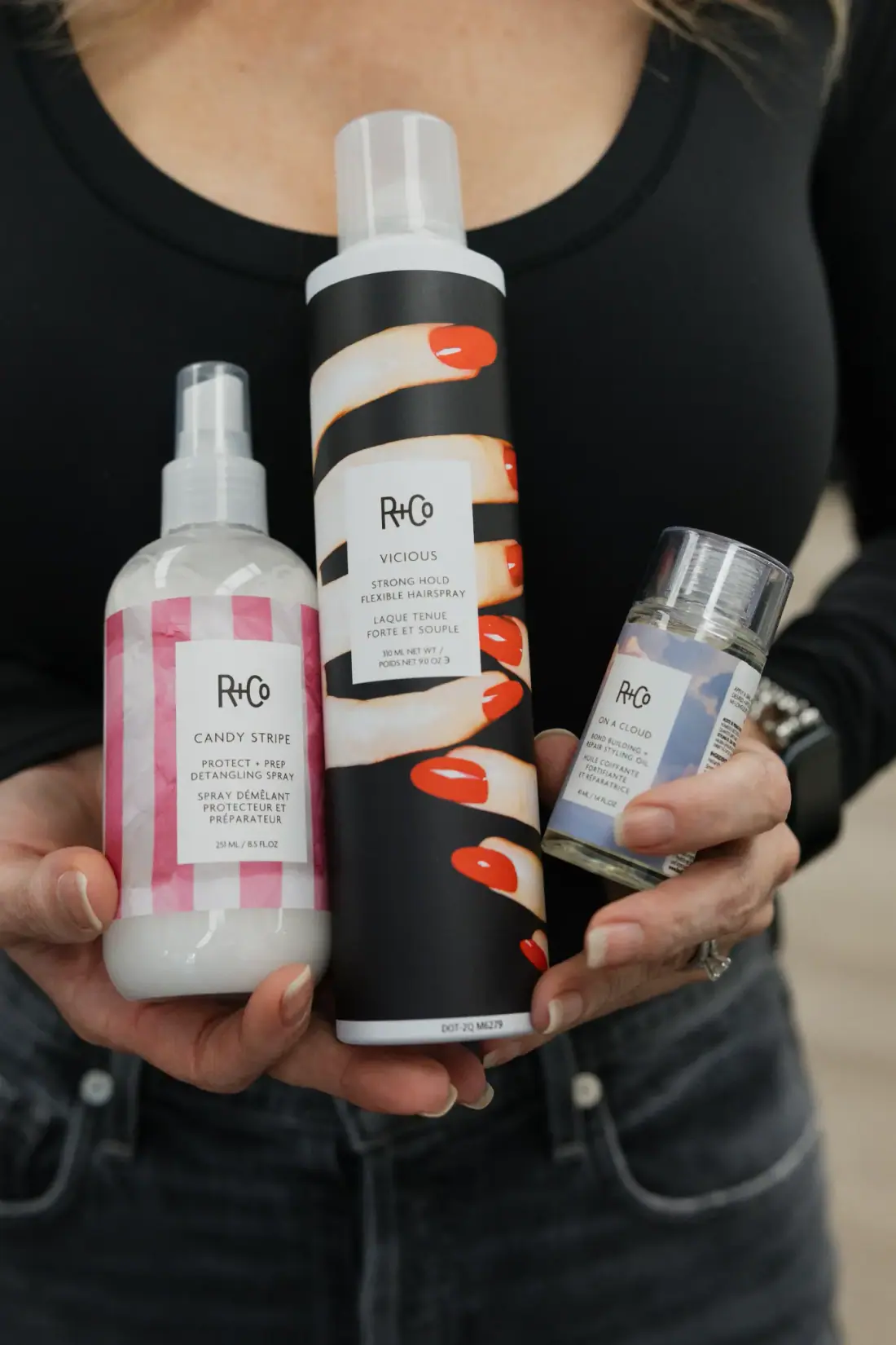 A stylist holding R+Co products at angelajoneshair, Palm Springs